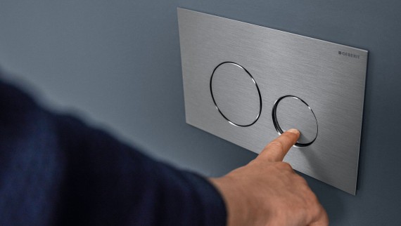 Hand actuates small flush at the Sigma40 Round actuator plate (© Geberit) Hand actuates small flush at the Sigma40 Round actuator plate (© Geberit)