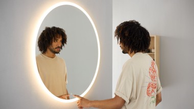 Lady in front of a mirror cabinet from Geberit